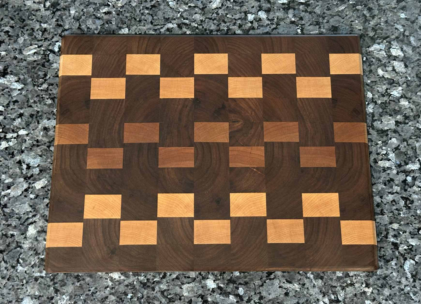 Checkered end grain cutting board featuring black walnut with cherry and maple hardwood accents.