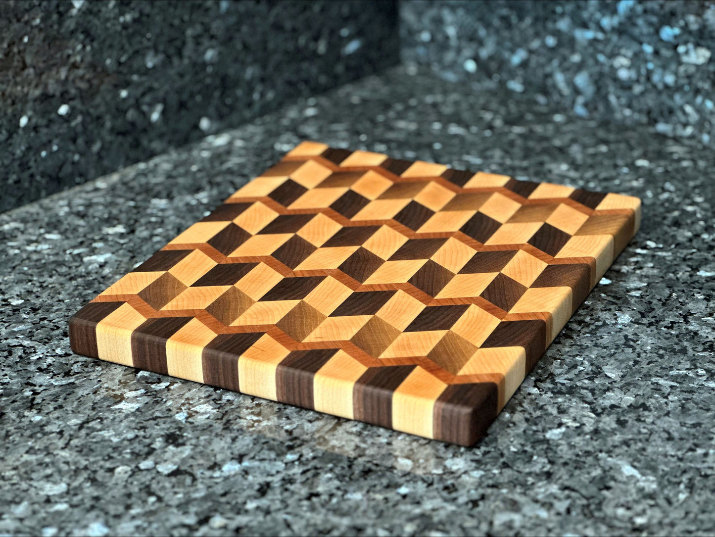Crafted from the finest hardwoods in North America, this chevron pattern inspired end grain butcher block features rich black walnut and maple with cherry accents. Board dimensions: 13"L x 12"W x 1"H. As a handcrafted product, please allow for approximately 1/4" variation in dimensions.