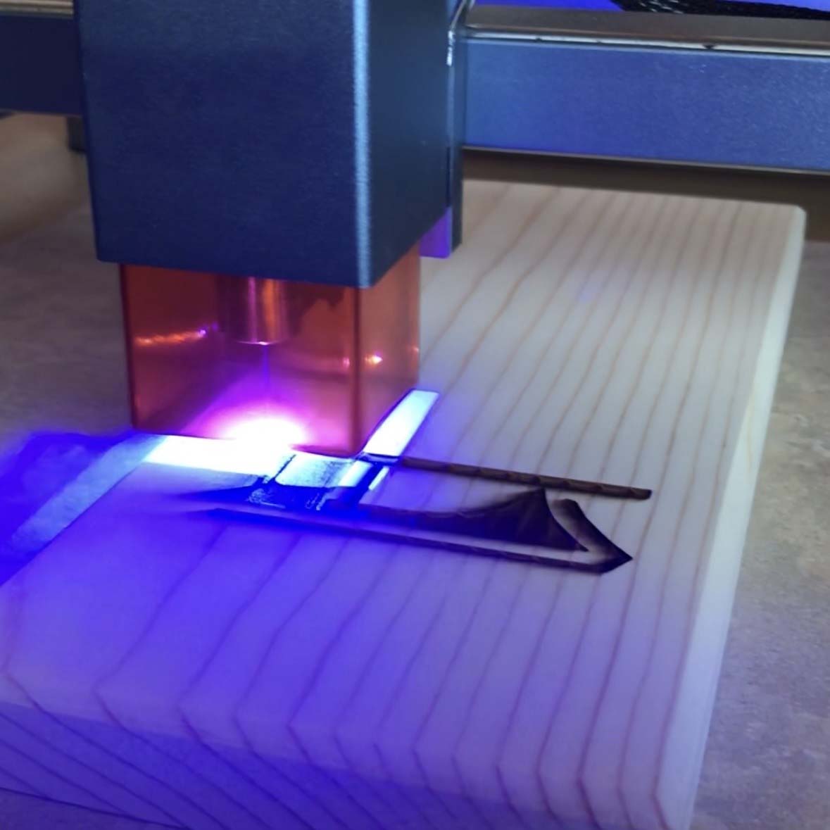 Laser engraver burning an image into wood for a custom order.