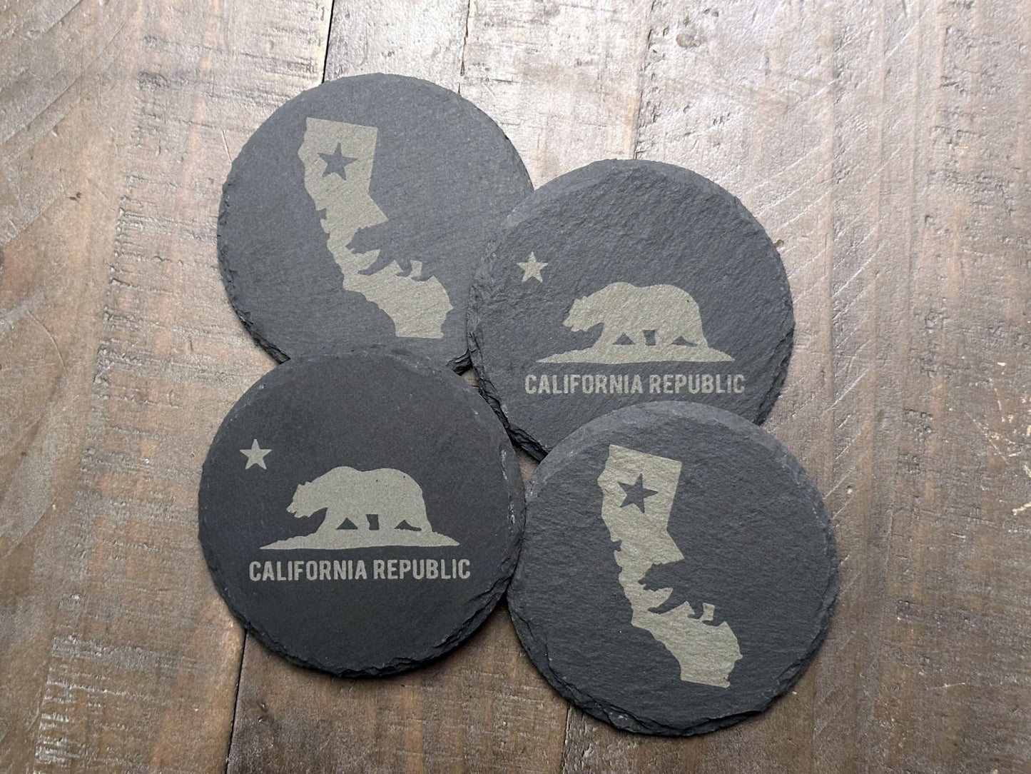 These California themed slate coasters are a real "bear" necessity to show off some state pride. Laser engraved with either the state's outline, lone star, and a grizzly bear or the California flag, they’re a bold way to keep your drinks in check. Made from durable slate, these coasters are both functional and stylish, making them a perfect addition to any home or as a gift for lovers of the Golden State.