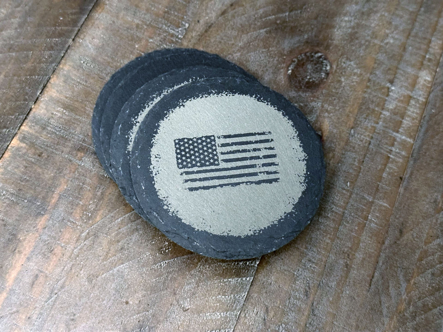 These USA themed slate coasters featured a US Flag design to show off that American pride. Laser engraved with either a light colored flag on a dark background or a dark colored flag on a light background, they’re a bold way to keep your drinks in check. Made from durable slate, these coasters are both functional and stylish, making them a perfect addition to any home or as a patriotic gift.