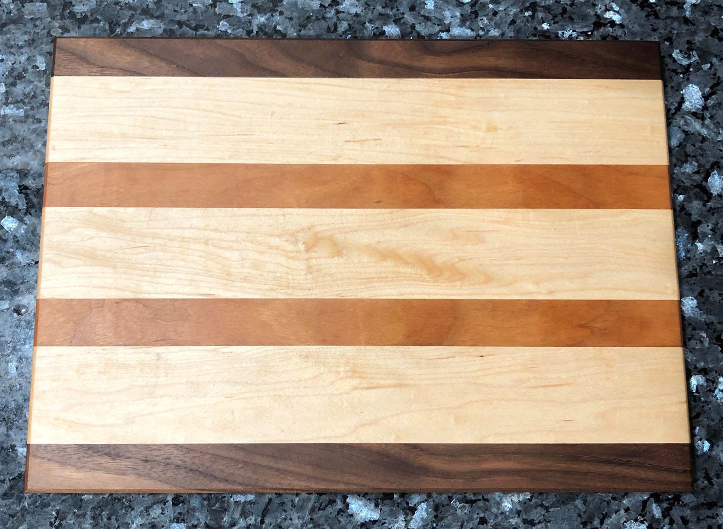 Long grain cutting board. Features black walnut, maple, cherry hardwoods.