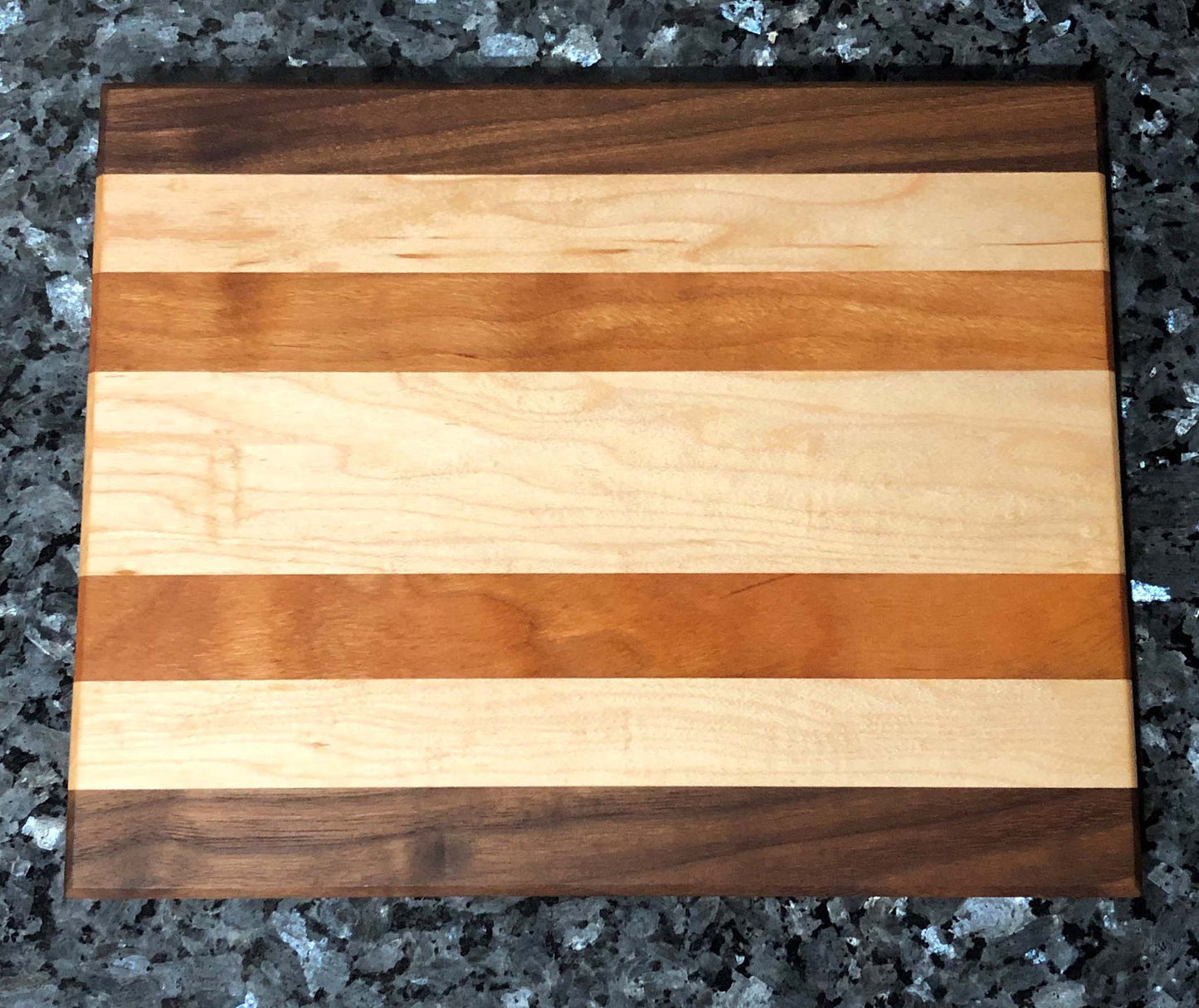 Long grain cutting board. Features black walnut, maple, cherry hardwoods.