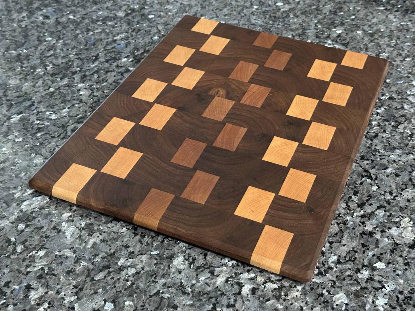 Checkered end grain cutting board featuring black walnut with cherry and maple hardwood accents.  