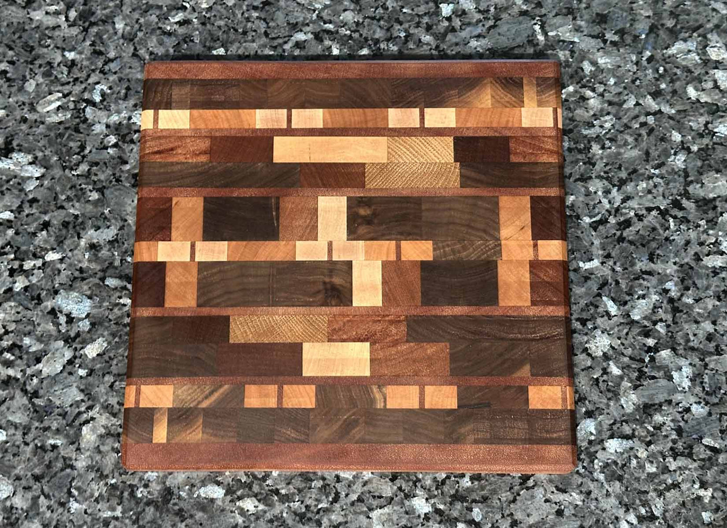 End grain cutting board with black walnut, mahogany, sapele, maple, cherry, and oak.