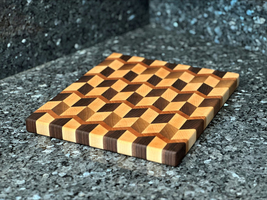 Crafted from the finest hardwoods in North America, this chevron pattern inspired end grain butcher block features rich black walnut and maple with cherry accents.  Board dimensions:  13"L x 12"W x 1"H.  As a handcrafted product, please allow for approximately 1/4" variation in dimensions.