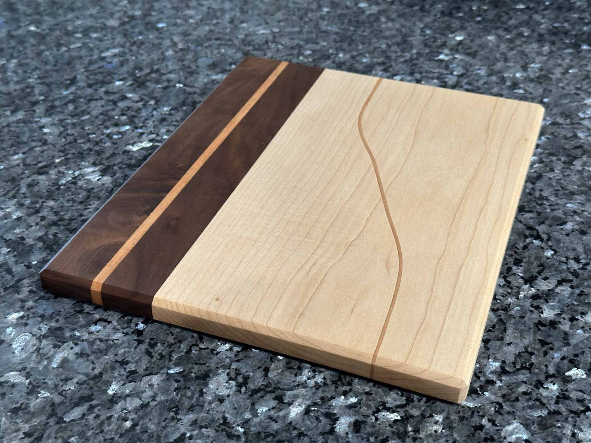 Long Grain Cutting Board with Black Walnut and Maple Hardwoods and Striking Cherry Accent by Space Rubber Ducky Designs.