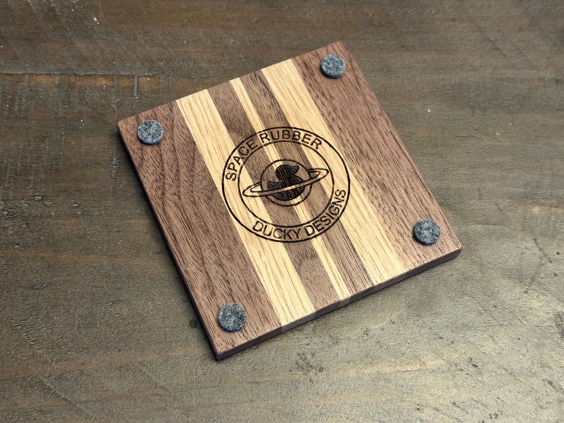 Enjoy a beverage while protecting your tabletops with these walnut and white oak hardwood coasters.  Available in a set of 4 coasters and includes a custom holder.  Each coaster is coated in polyurethane for water resistance and they have felt footpads to protect your surfaces.  As a handmade wood product, there will be slight variation between the product you receive and the listed images.