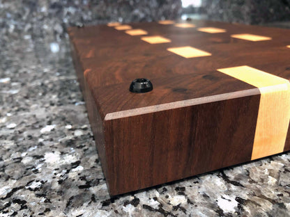 End grain butcher block. Features hardwoods, black walnut with maple accents. Chamfered edges and finger grooves. Hard rubber feet for stability and air circulation.